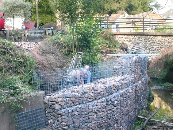people installing a gabion wall