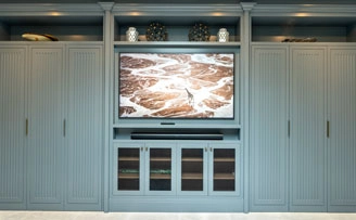 Bespoke cabinetry with crimped mesh grille for tv equipment.