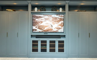 Bespoke cabinetry with crimped mesh grille for tv equipment.